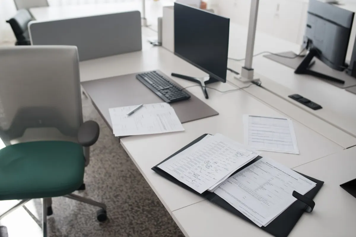 Mesa de escritório organizada com documentos e computador
